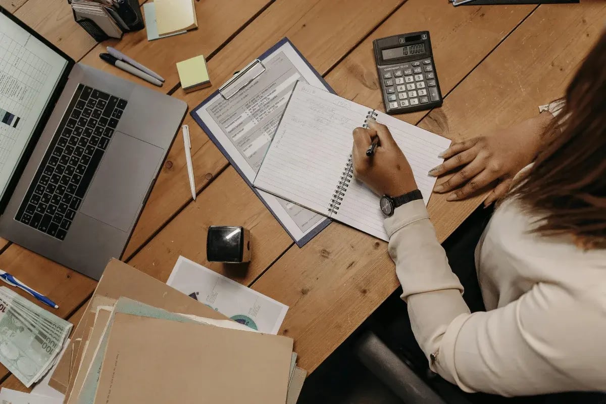 Business professional managing expenses with handwritten notes and spreadsheets.