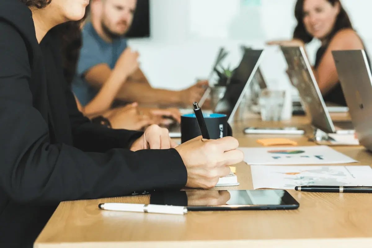 Business team in a meeting taking notes and discussing strategy.
