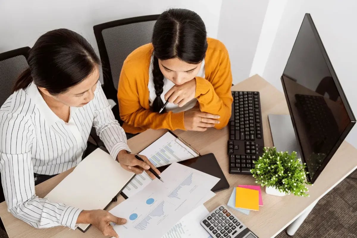 Overhead view of coworkers analyzing financial data.