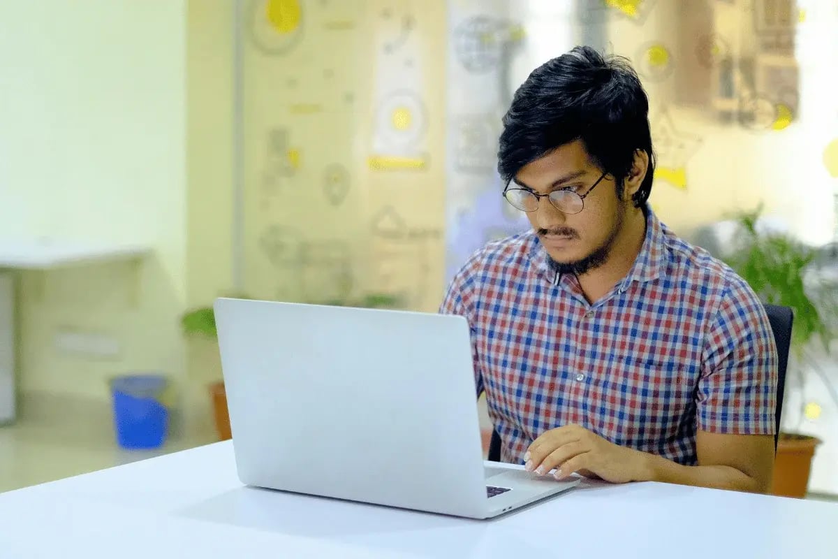 Focused professional working on laptop in office.