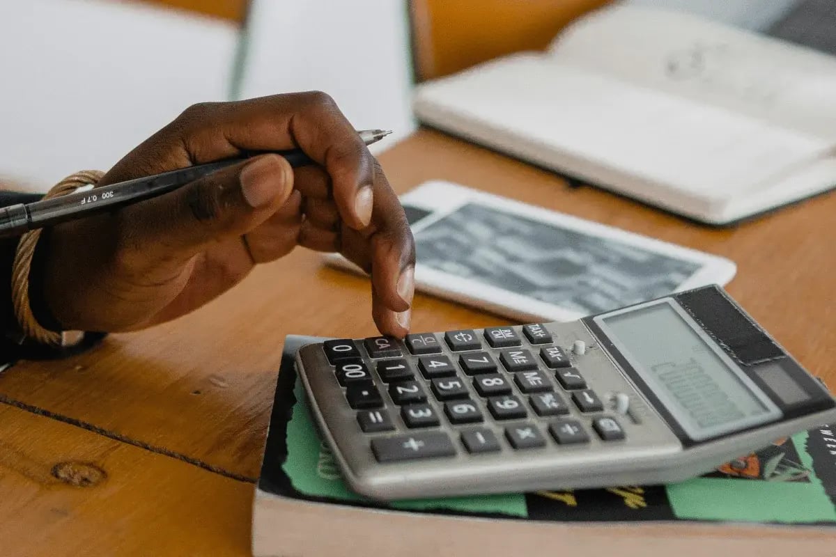 Close-up of person using calculator for financial work.