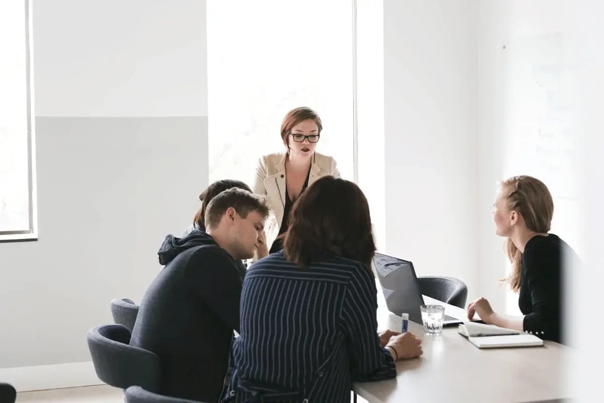 Businesswoman leading a team meeting in a bright modern office.