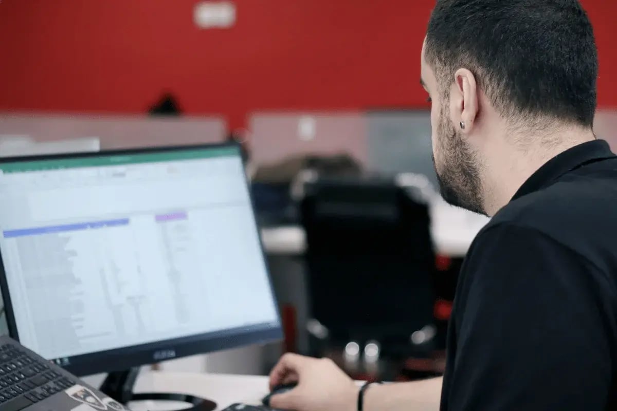 Close-up of employee analyzing business reports on a large screen.